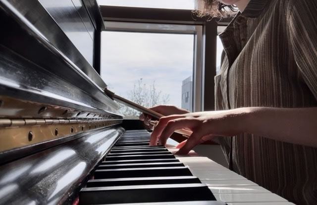 A photo of me at the piano, completing my third species counterpoint homework for one of my classes, Music Mechanics